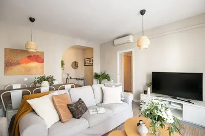 a living room with a white couch and a flat screen tv at Eixample Barcelona Luxury for 8 in Barcelona