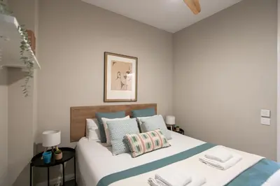 a bedroom with a bed with blue and white pillows at Eixample Barcelona Luxury for 8 in Barcelona