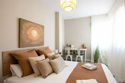 a bedroom with a large bed with brown and white pillows at Eixample Barcelona Luxury for 8 in Barcelona