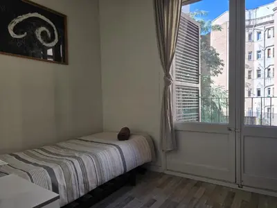 a bedroom with a large bed and two night stands at little 3 bedrooms apartement barcelona center in Barcelona