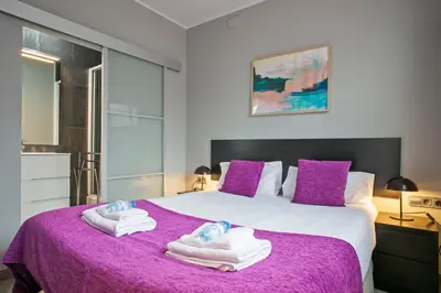 a bedroom with a purple bed with towels on it at Alcam Entenza in Barcelona