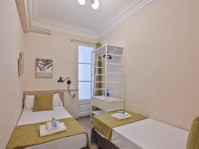 a bedroom with two beds and a shelf at Alcam Entenza in Barcelona