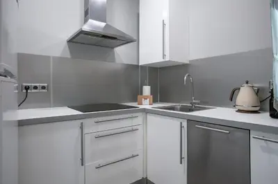 a kitchen with white cabinets and a sink at Alcam Entenza in Barcelona