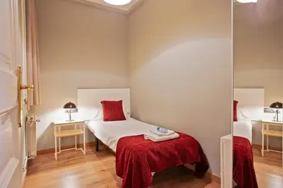 a small room with a bed and a mirror at Alcam Entenza in Barcelona