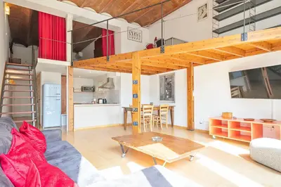 a living room with a loft bed and a table at Alcam Paseo de Gracia in Barcelona