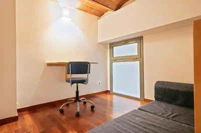 a bedroom with a desk and a chair next to a bed at Alcam Paseo de Gracia in Barcelona