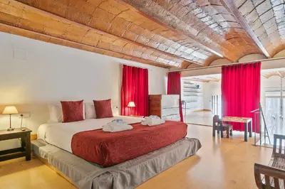 a bedroom with a large bed with red curtains at Alcam Paseo de Gracia in Barcelona