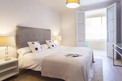 a white bedroom with a large bed with white sheets and pillows at Ola Living Broto in Barcelona