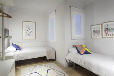 two beds in a room with white walls at Ola Living Broto in Barcelona