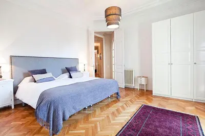a bedroom with a large bed and a purple rug at Bcncaliu in Barcelona
