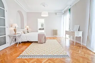 a white bedroom with a bed and a desk at Bcncaliu in Barcelona