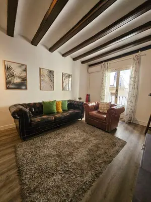a living room with a leather couch and a chair at Five Room Family Flat Near Ramblas in Barcelona