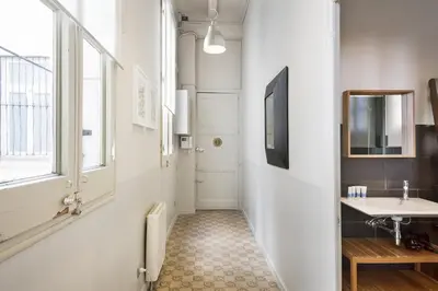 a hallway with a bathroom with a sink and a mirror at Ola Living Gaudi in Barcelona