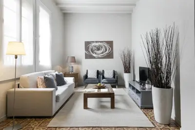 a white living room with a couch and a table at Ola Living Gaudi in Barcelona