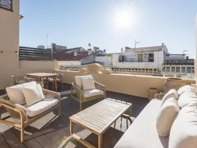 a balcony with chairs and tables on a roof at 'The Residences At Bartomeu 26 ' Suite Benazet in Sitges