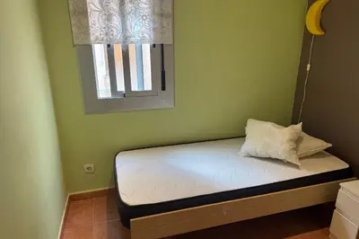 a small bed in a green room with a window at NEW! Apartment for 4 people near the beach in Poblenou in Barcelona