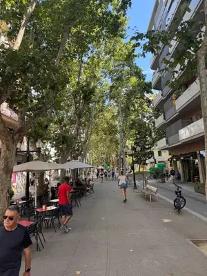 people walking down a city street with tables and trees at NEW! Apartment for 4 people near the beach in Poblenou in Barcelona