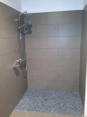 a bathroom with a shower with a tiled shower at Hotel Can Ribalta in San Antonio de Vilamajor