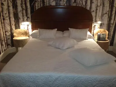 a bed with white sheets and pillows on it at Hotel Can Ribalta in San Antonio de Vilamajor