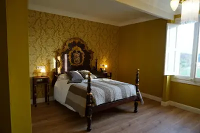 a bedroom with a bed in a room with green walls at Hotel Can Ribalta in San Antonio de Vilamajor