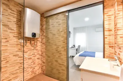 a bathroom with a shower and a bedroom at Laramond Barcelona Rooms in Barcelona