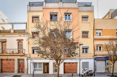 an apartment building with a tree in front of it at Laramond Barcelona Rooms in Barcelona