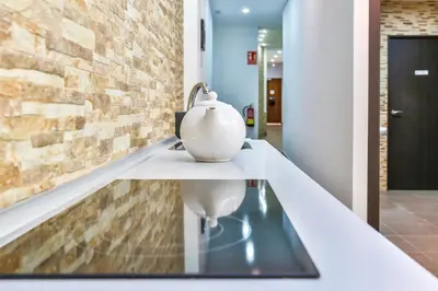 a white vase on a glass table in a hallway at Laramond Barcelona Rooms in Barcelona