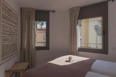 a bedroom with a bed and two windows at Lodging Apartments Besos River 11 in Santa Coloma