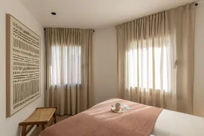 a bedroom with a bed with a tray of food on it at Lodging Apartments Besos River 11 in Santa Coloma