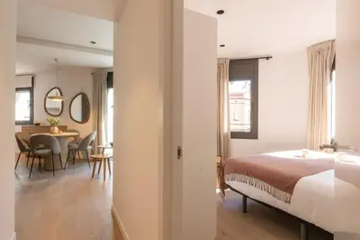 a bedroom with a bed and a dining room at Lodging Apartments Besos River 11 in Santa Coloma