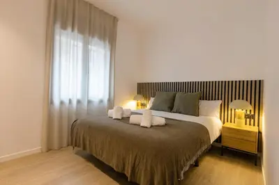 a kitchen with a table and chairs and a chandelier at Lodging Apartments Besos River B1 in Santa Coloma