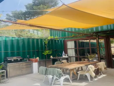 an outdoor kitchen with a wooden table and chairs at Designer villa with sauna and swimming pool in Canyelles