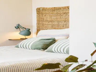 a bed with two pillows and a lamp on a table at Designer villa with sauna and swimming pool in Canyelles