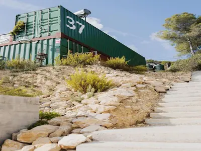 a building on top of a hill with rocks at Designer villa with sauna and swimming pool in Canyelles