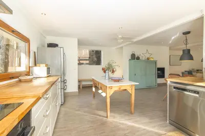 a kitchen with a table and a refrigerator at Casa con encanto a los pies del Montseny in La Batlloria
