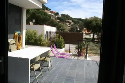 a view of a patio with a table and chairs at Casa ceca de la Playa y Barcelona, con piscina climatizada y jacuzzi in Vallromanas