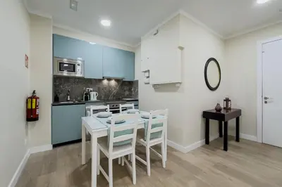 a kitchen and dining room with a white table and chairs at Habitación 5 con baño junto al Palau Güell in Barcelona