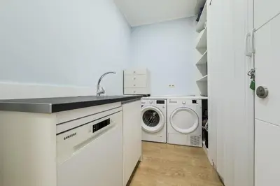 a white laundry room with a washer and dryer at Habitación 5 con baño junto al Palau Güell in Barcelona