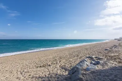 a sandy beach with the ocean in the background at HomeHolidaysRentals Pinedalovers - Costa Barcelona in Pineda de Mar