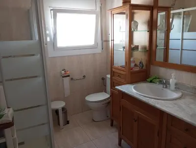 a bathroom with a toilet and a sink and a window at Un lugar tranquilo y relajado in La Salud