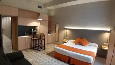 a hotel room with a bed and a kitchen at Casa Abamita in Barcelona