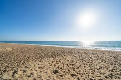 a sandy beach with the ocean in the background at HomeHolidaysRentals Magic - Costa Barcelona in Pineda de Mar