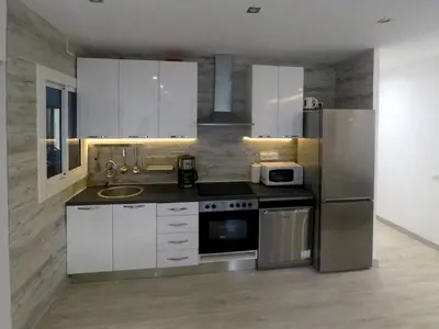 a kitchen with white cabinets and stainless steel appliances at YOUR HOME - Sagrada Familia Apartment in Barcelona