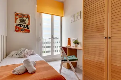 a bedroom with a bed and a desk and a window at 4 Bedroom High-Rise Apartment Amazing views! in Barcelona