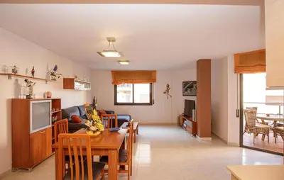 a kitchen and living room with a table and a couch at Beautiful Apartment In Pineda De Mar in Pineda de Mar