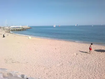 a boy standing on a beach near the water at Apartment Llavaneres II in Sant Andreu de Llavaneres