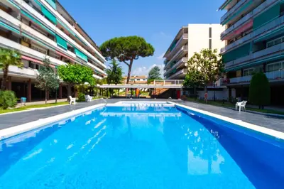 a large blue swimming pool next to a building at Apartment Llavaneres II in Sant Andreu de Llavaneres