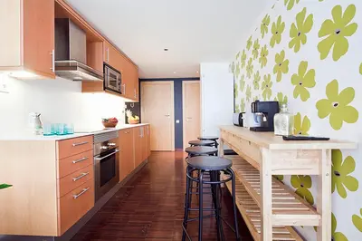 a kitchen with wooden cabinets and a counter with stools at My Space Barcelona Private Pool Garden in Barcelona