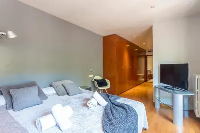 a bedroom with a bed with a television and a desk at My Space Barcelona Bonanova Center in Barcelona
