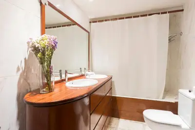 a bathroom with two sinks and a vase of flowers at My Space Barcelona Bonanova Center in Barcelona
